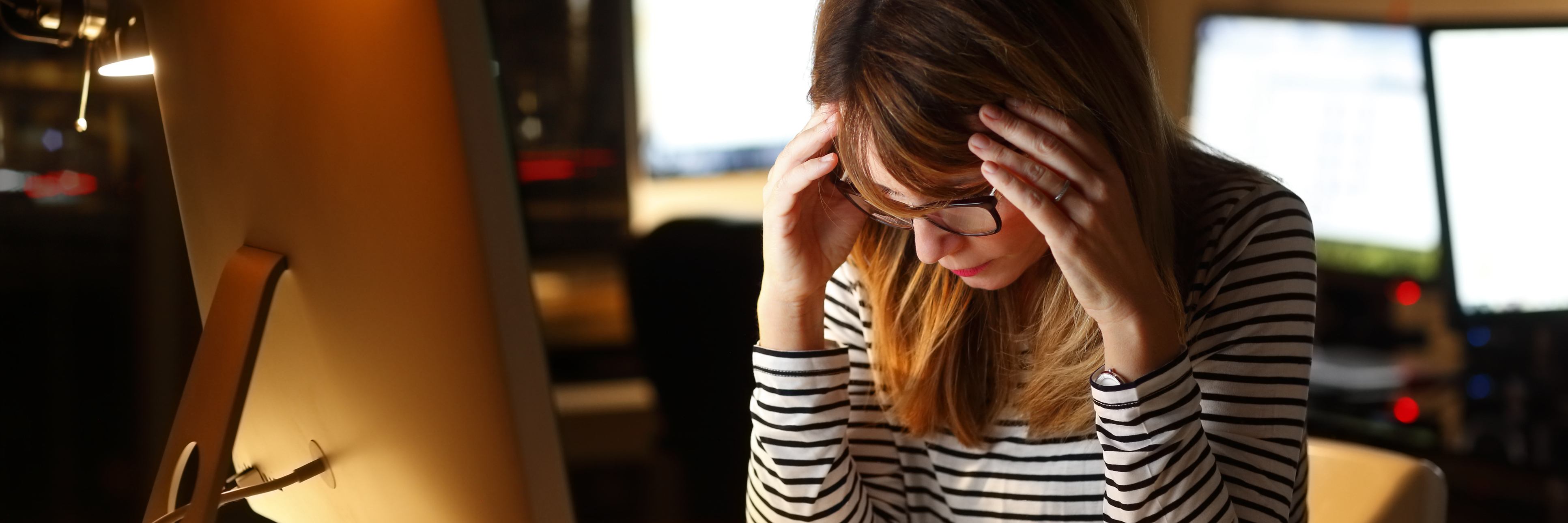 Things I Want My Boss to Know as an Employee With C-PTSD young businesswoman sitting at office desk tired stressed head in hands