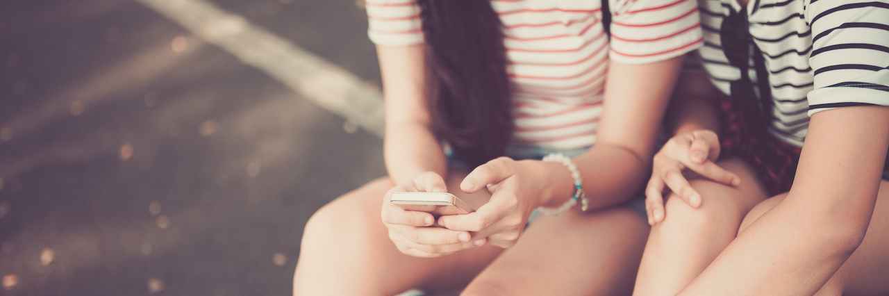 The Text That Meant the Most in my Self-Harm Recovery a woman on her phone