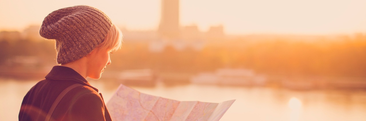 The Difficult Truths About Eating Disorder Recovery A woman holding a map standing in front of a city