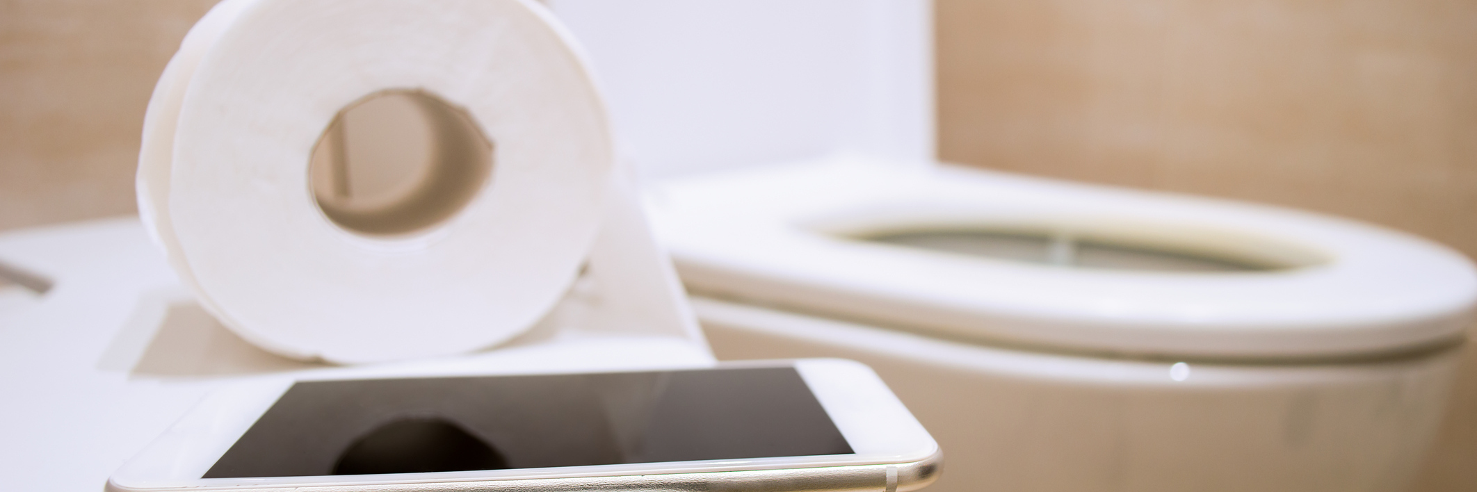 A Humorous Perspective on Irritable Bowel Syndrome Close up of toilet paper and an iPad with a toilet in the background.