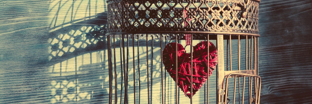 When You Feel Trapped in Depression, and How to Find Freedom heart trapped inside vintage birdcage with shadows cast on wall