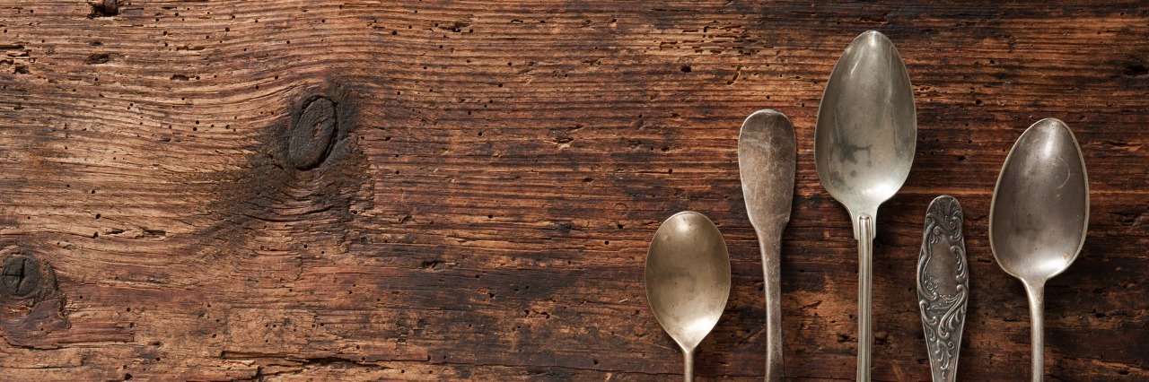 Vintage metal spoons on wooden table