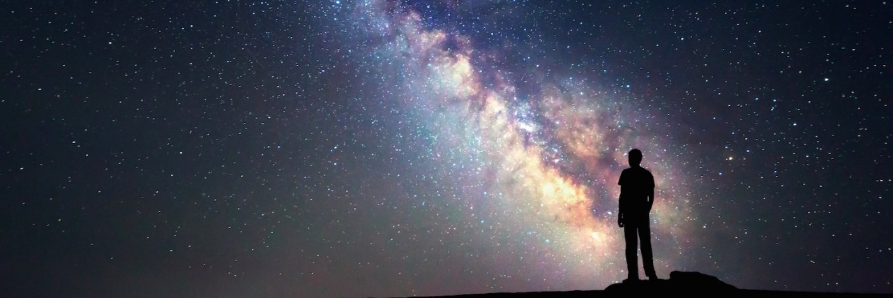 How an Adult Diagnosis of Autism Helped Me Find Myself Silhouette of man standing in front of star-filled and Milky Way night sky landscape