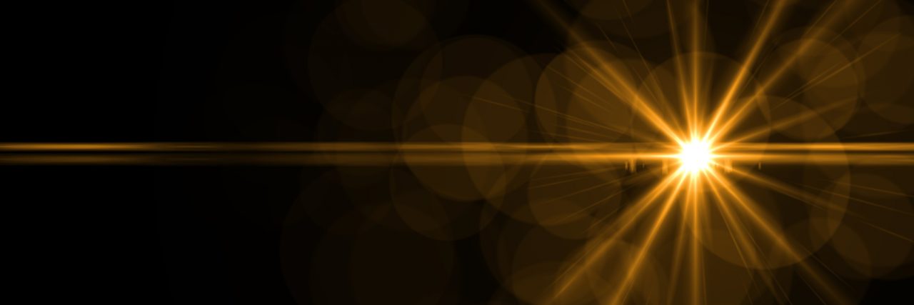 The 'Glimmer of Hope' on the Good Days With Lyme Disease Black background with a golden light shining in the darkness.