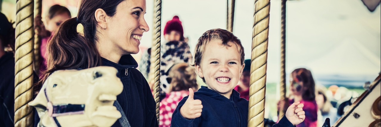 mother and son riding on a carousel