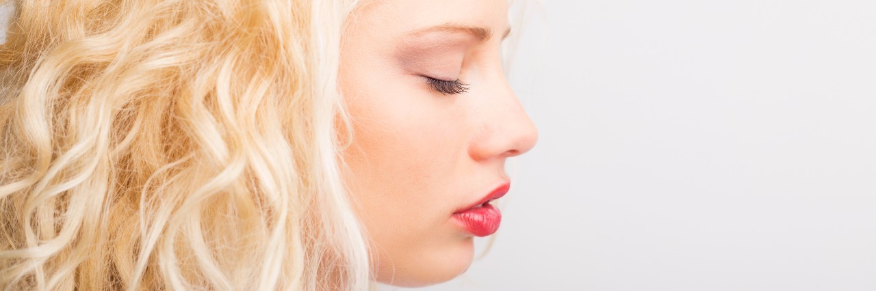 Profile photo of blonde woman with eyes closed.