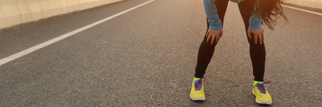 Hypotonia and Gym Class in School Tired woman runner taking a rest after running.