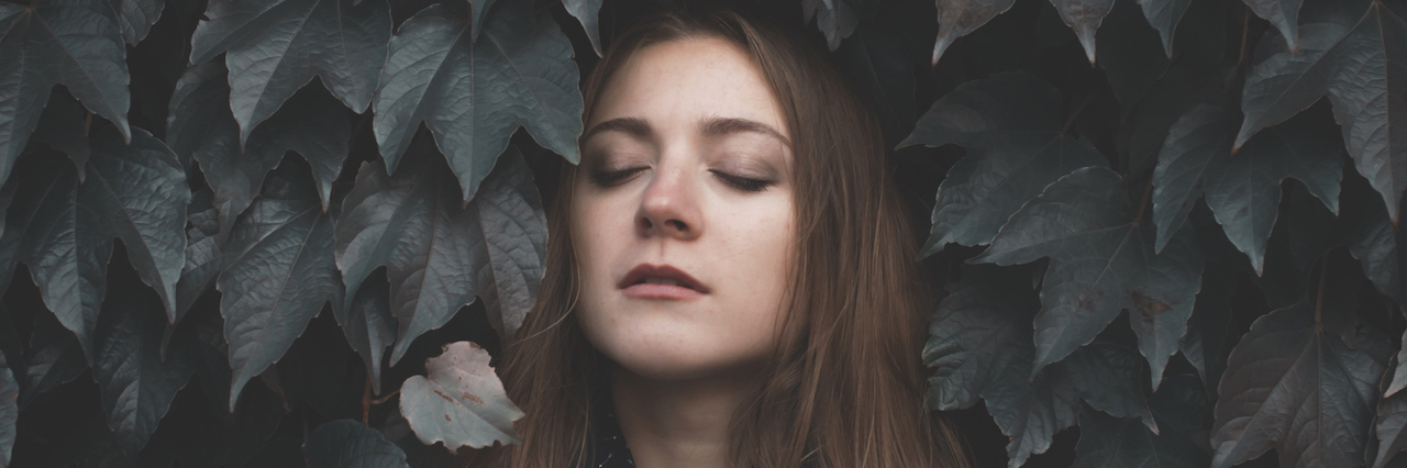 The Meltdown That Made Me Realize I Was Actually Getting Better A woman leaning into a tree