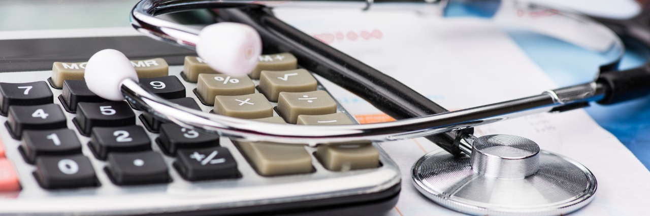 calculator and stethescope on paperwork