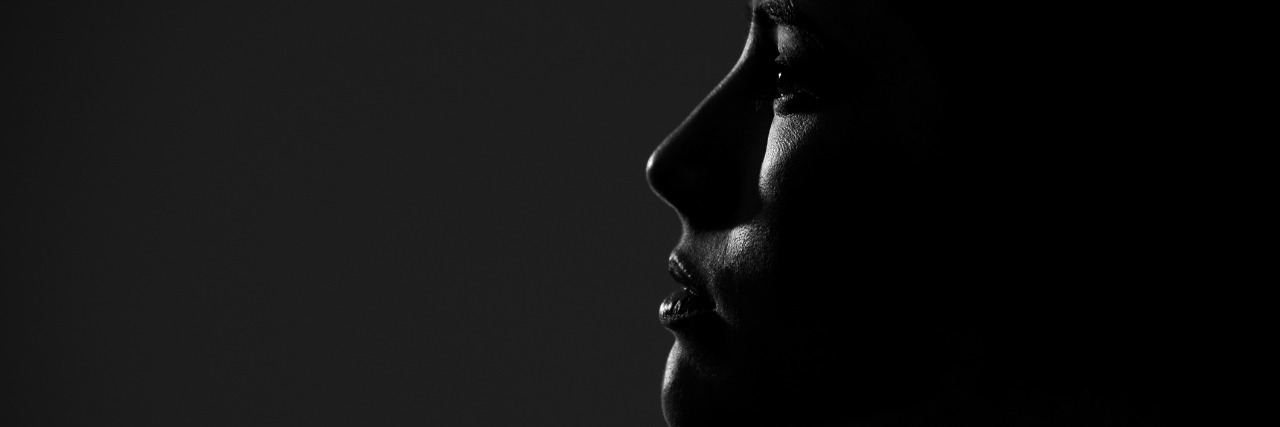 The Hidden Symptoms of Invisible Illness Abstract silhouette of young pretty woman looking away. Profile view.