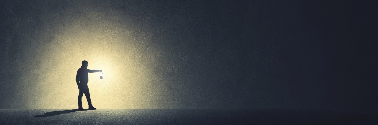 Letter to Person Struggling With Isolation of Chronic Pain, Illness person walking alone in darkness illuminated by a lamp