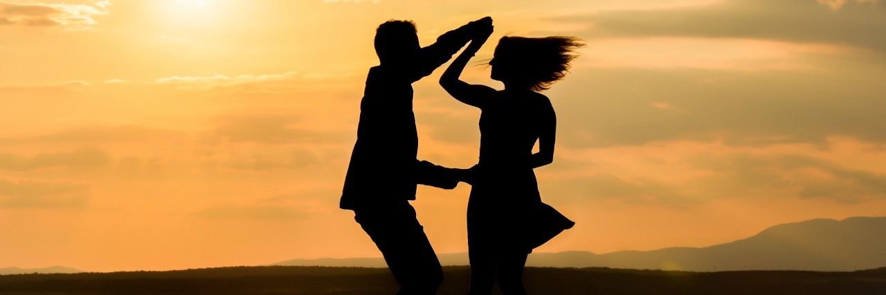 Re-Learning How to Live With Chronic Illness silhouette of man and woman dancing together by the ocean at sunset