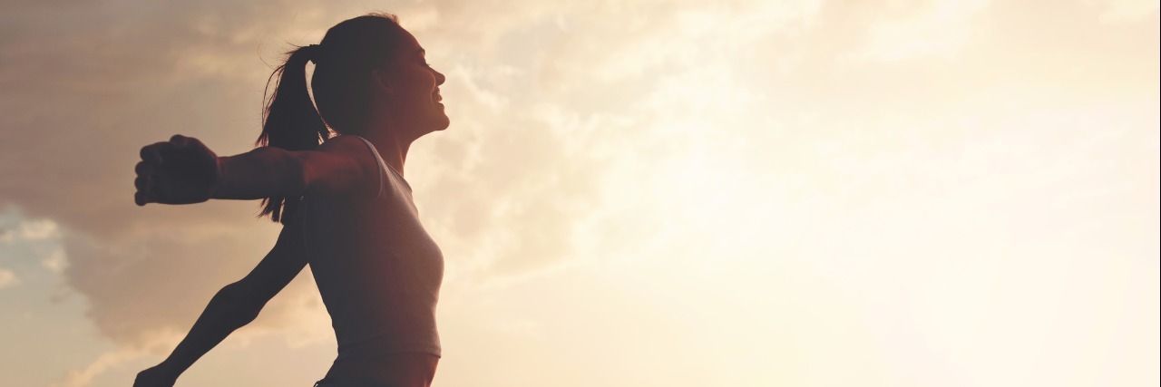 Being Open and Sharing Struggles With Chronic Illness woman standing outside with her arms spread open