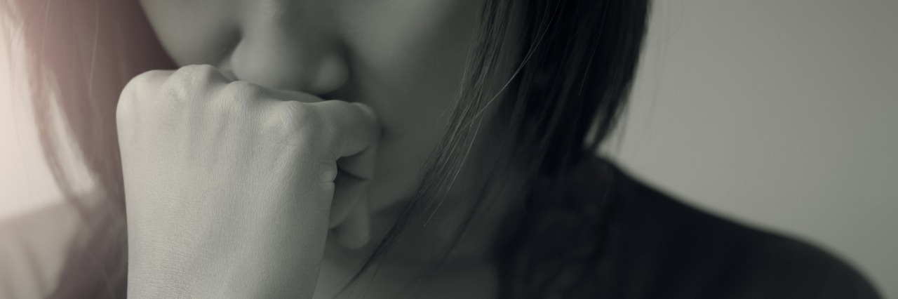 Being at the Mercy of Doctors, Loved Ones With Chronic Illness woman frowning with her hand resting on her face
