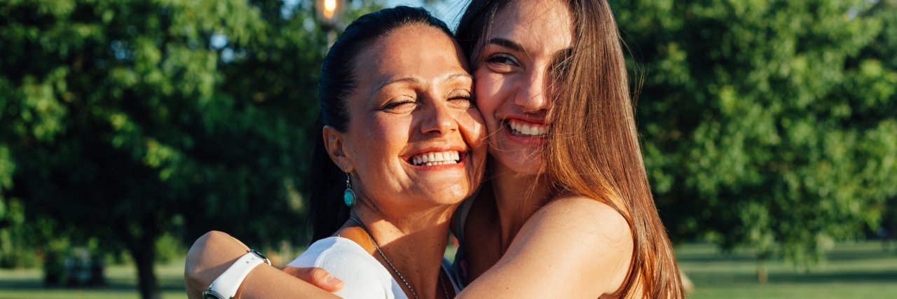 To My 'Warrior Mom' Who Helped Me Through Depression Cute pretty teen daughter with mature mother laughing and hugging in nature at sunset