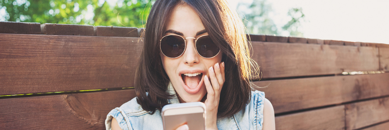 Happy young woman using smart phone