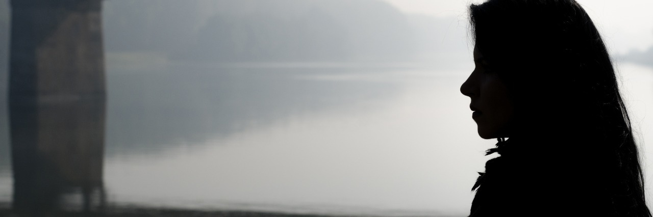 Fibromyalgia: Realizing Pain Won't Go Away silhouette of a woman walking over a gloomy bridge