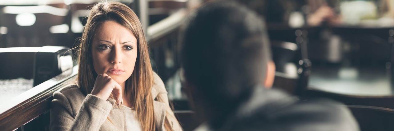 Ehlers-Danlos Syndrome: Online Dating With a Chronic Illness man and woman on a date at a bar, and the woman is frowning