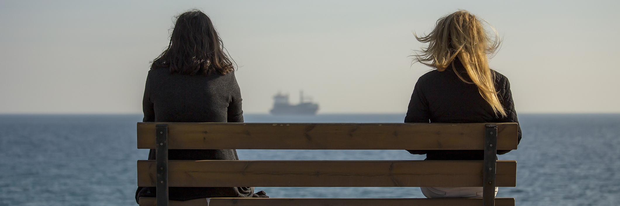 How Relationships Can Change After a Brain Injury two women sit bench near beach