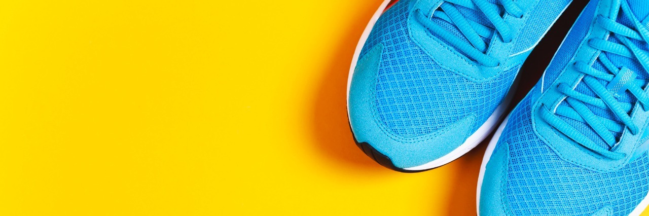 How I've Reclaimed Exercise in Eating Disorder Recovery Blue sneakers, water and apple on black background. Concept of healthy lifestile and food, everyday training and force of will.