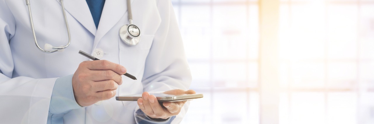 doctor writing on a tablet