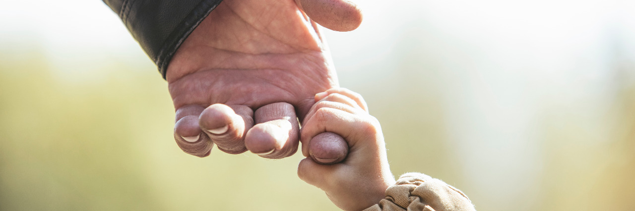 The Family and Medical Leave Act Should Cover Next of Kin Child holding hands with grandparent.