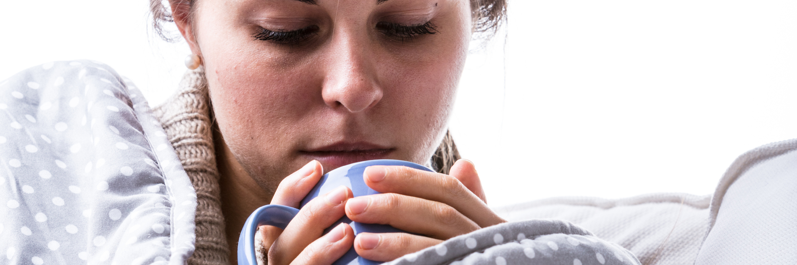 What a Panic Attack 'Comedown' Feels Like woman wrapped up in blanket on sofa