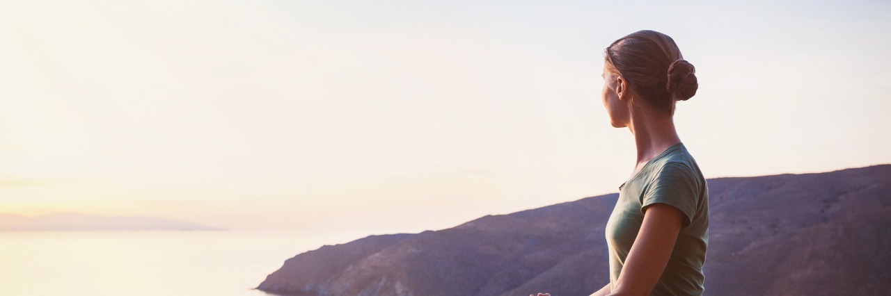 Importance of Acceptance in Life With Chronic Illness woman meditating and looking at the sunset
