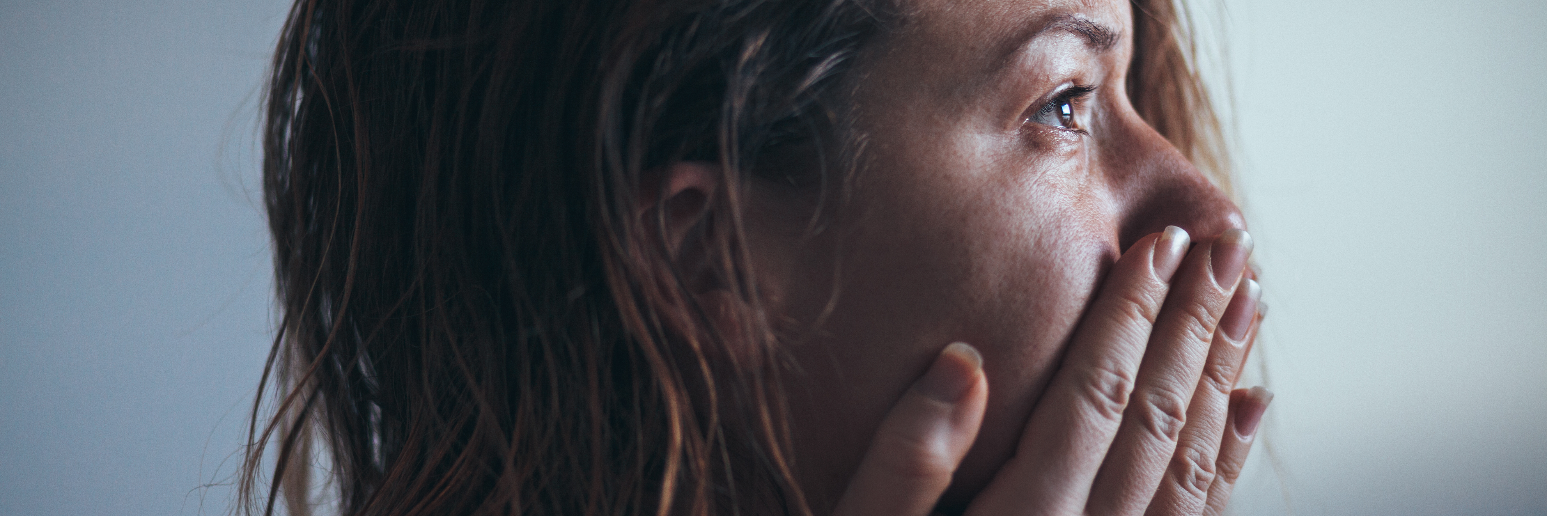 How I've Spent 14 Years Avoiding the Reason for My PTSD young woman sitting alone in profile crying