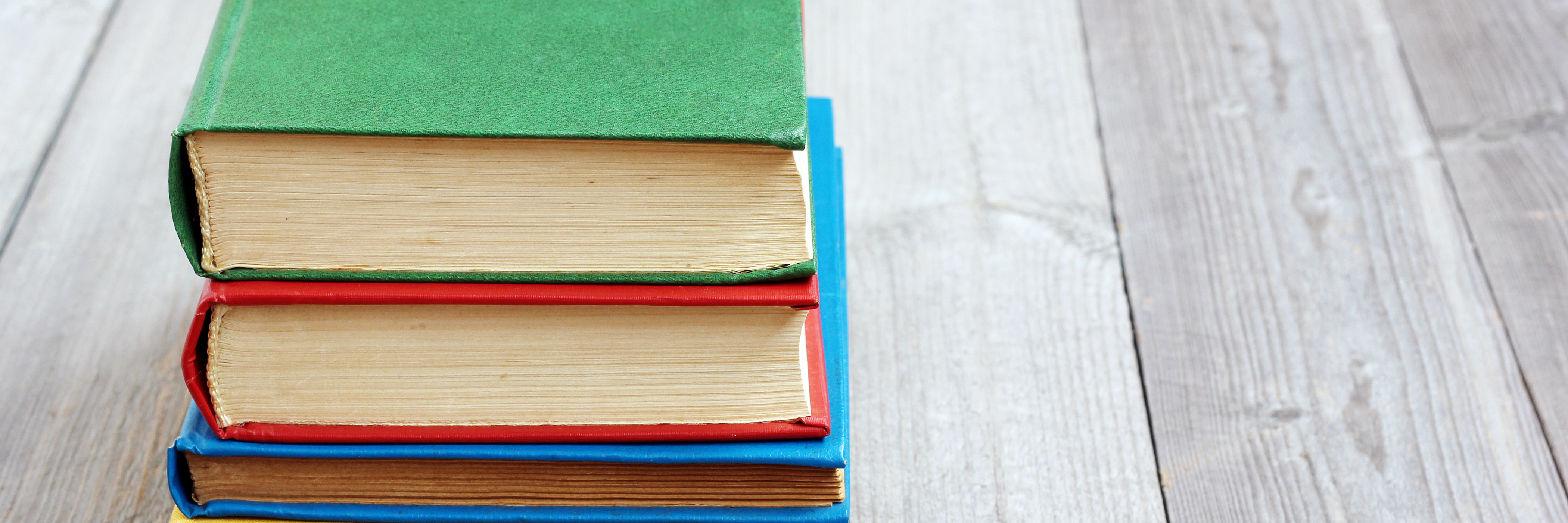 Best Books to Read in Eating Disorder Recovery Four open books in the colored cover on the table made of boards.A stack of books in the colored covers on the table with a red tablecloth. Still life with books.