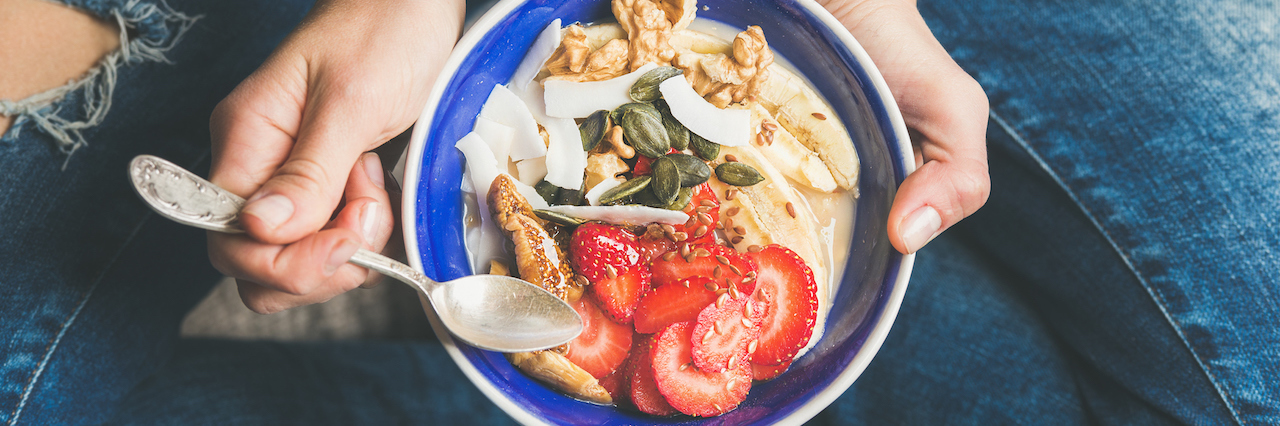Post-Meal Mindfulness in Eating Disorder Recovery Woman eating a bowl of yogurt