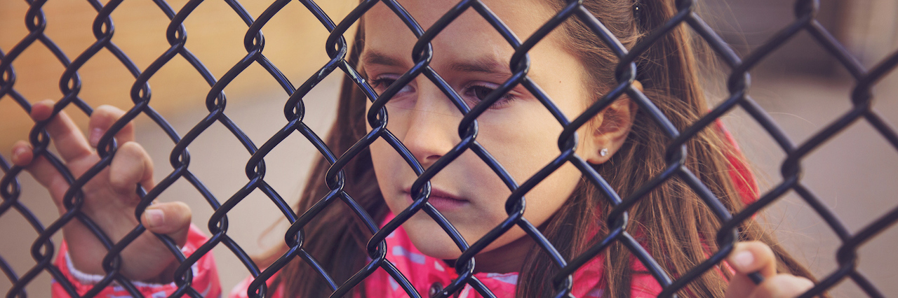 Living With Parents With Alcoholism and Addiction young sad, girl looking through a fence