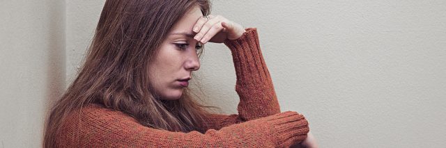 woman sitting alone in corner with depression