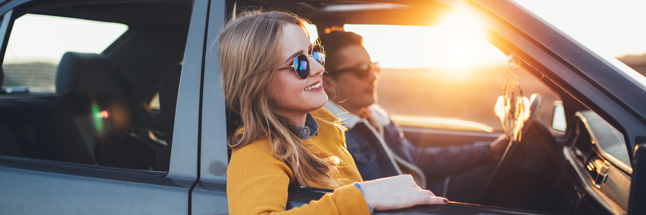 Trying New Things, Changing Perspectives With Chronic Illness woman leaning out a car window on a road trip with the sun behind her