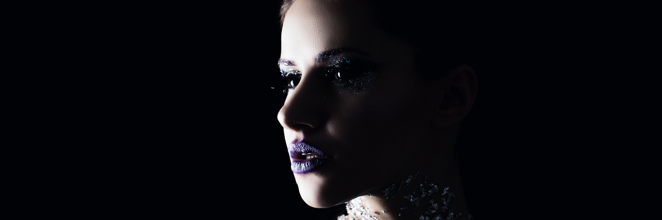 What Doctors and Media Leave Out About Living With a Chronic Illness Woman sits in dark, with creative makeup on, thinking.