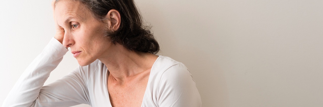 Asthma, Diabetes: Telling People 'I'm Fine,' 'I'm OK' woman leaning on the arm of her couch looking upset