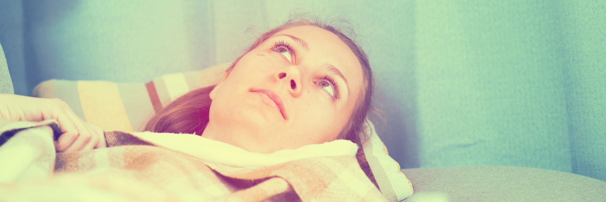 woman lying in bed and looking at the ceiling