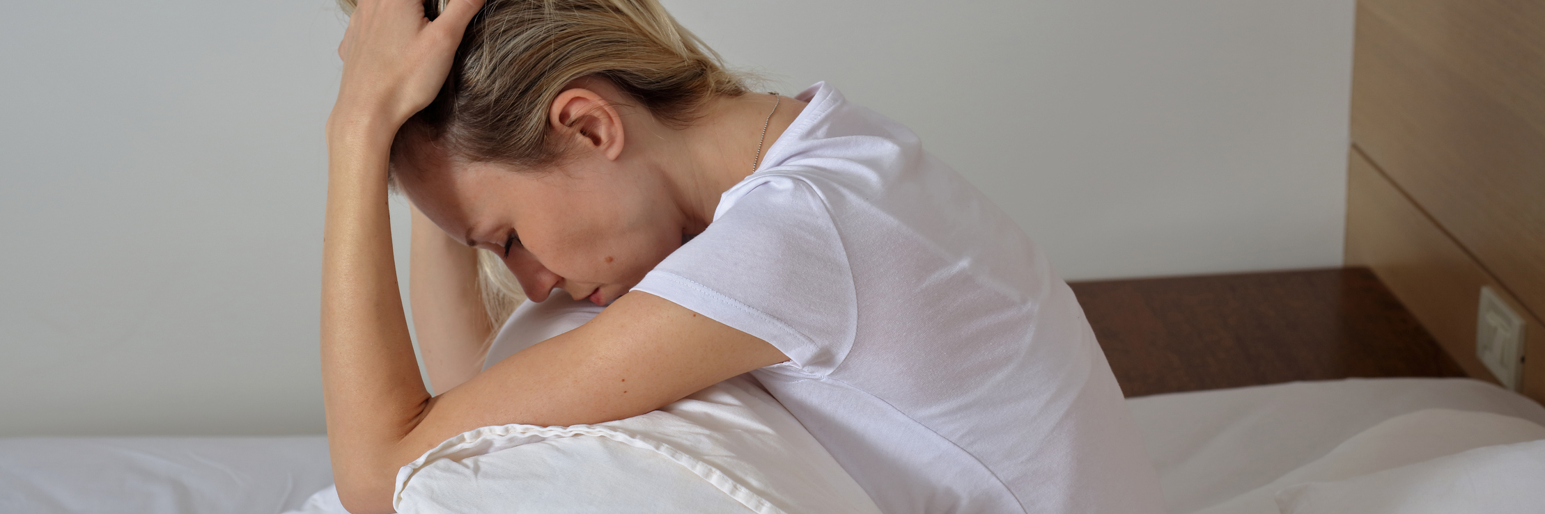 Doubting Your Symptoms When You Don't Have a Diagnosis woman sitting in bed frustrated