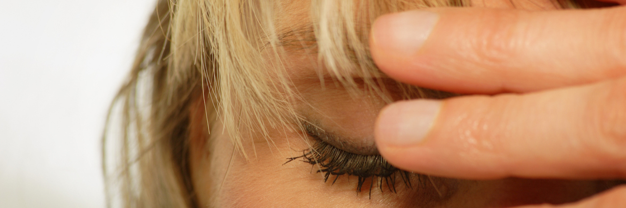 The Struggle of Experiencing Chronic Pain and an Eating Disorder woman with a headache