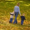 Mother walking on grass, holding hands of her two sons