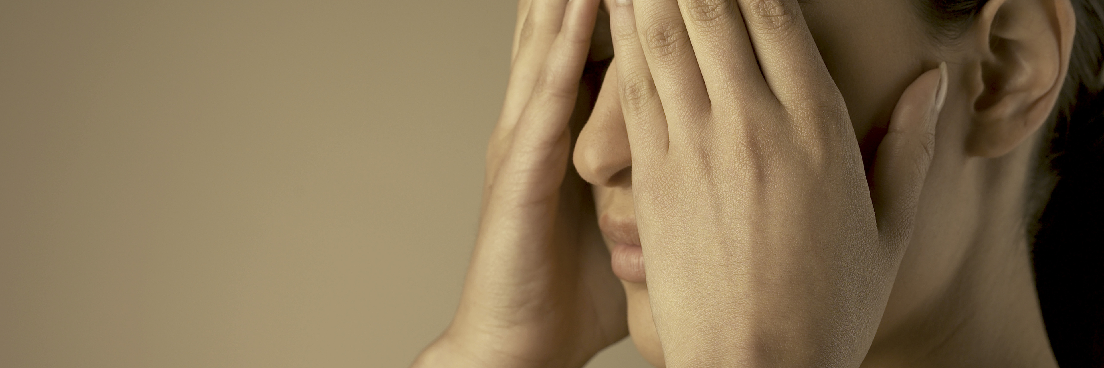 woman covering eyes with hands