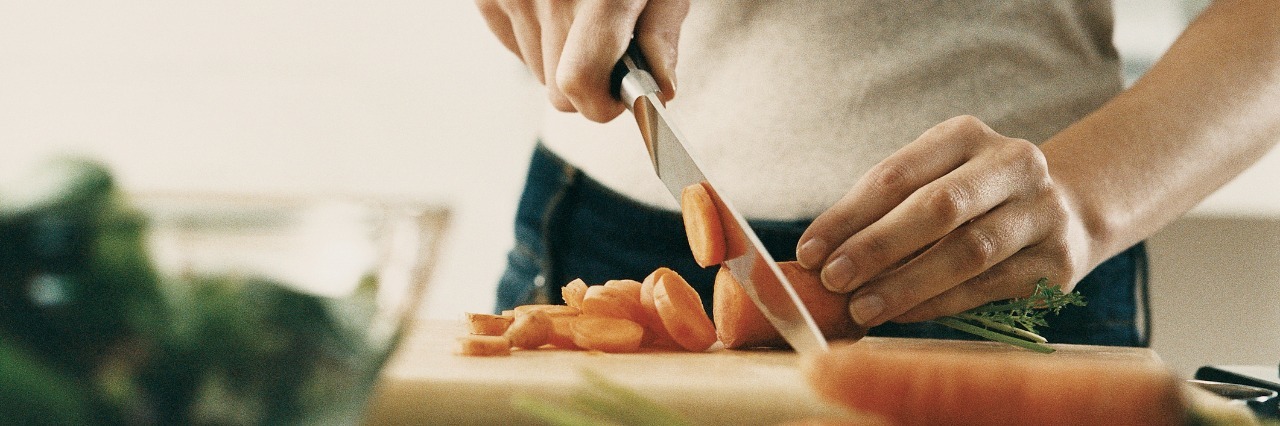 Woman cutting vegetables for meal.