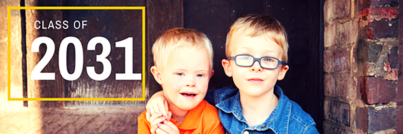 Twin boys with blonde hair. One wears glasses and the other has Down syndrome.