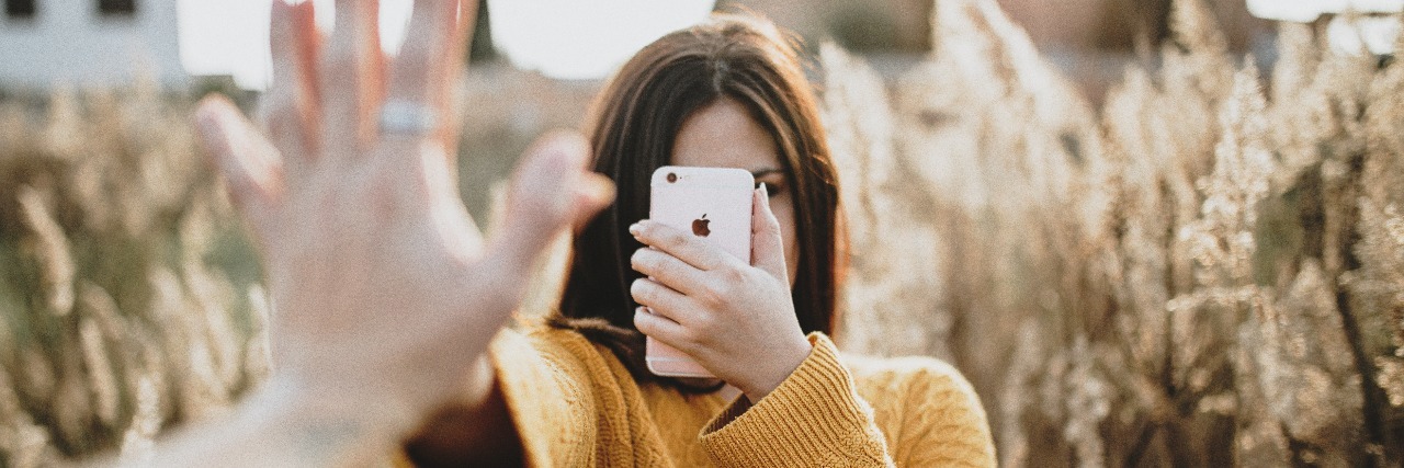 Why the #BoycottTheBefore Movement Is So Important woman taking photo on phone with outstretched hand to person taking photo of her