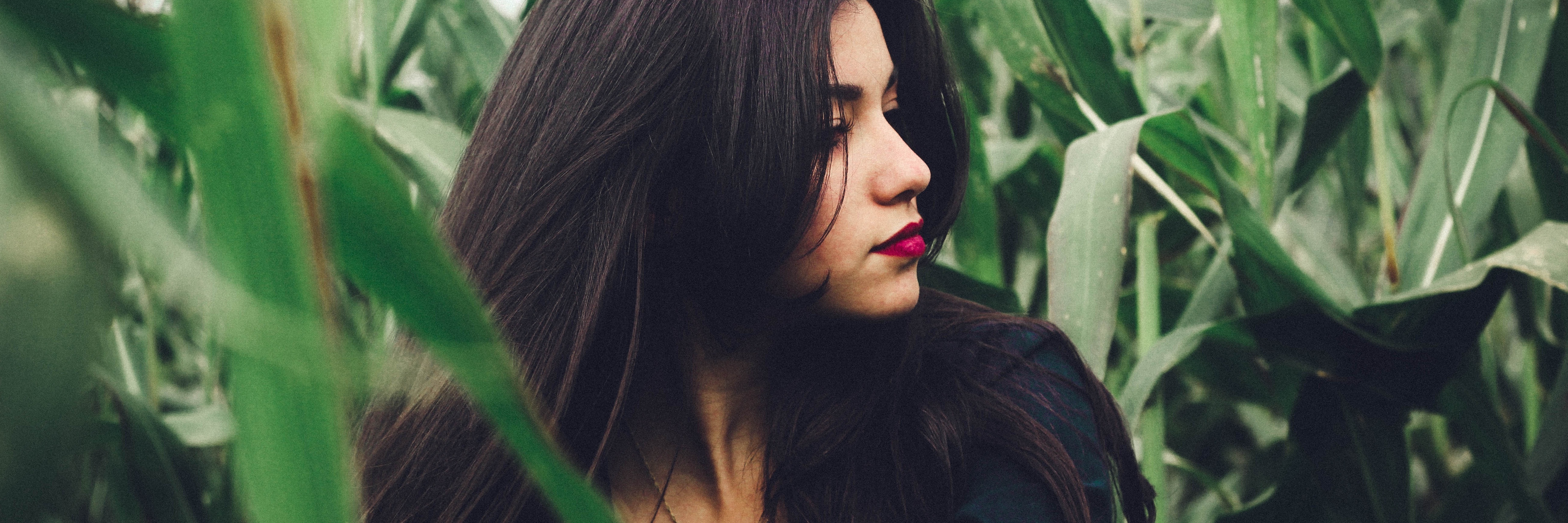 Rumination and Anxiety: What It Is and How It Affects Me dark haired woman in cornfield lost in thought