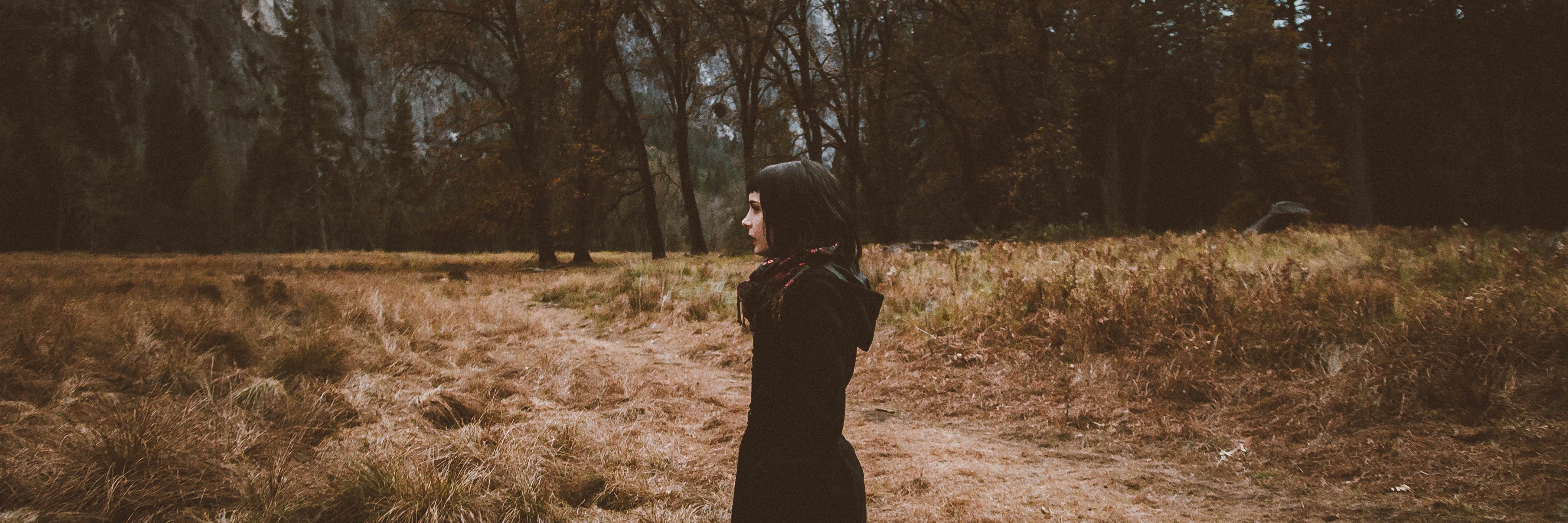 Fighting the Misconception of What Anorexia Looks Like young woman in profile wearing dark clothes in nature by trees