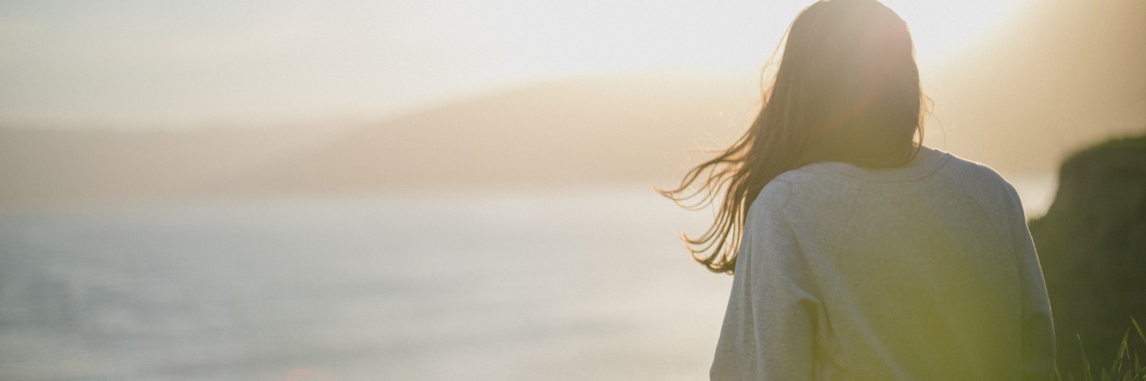 Lost Friendships Because of Fighting Depression young woman looking out to sea with land in distance