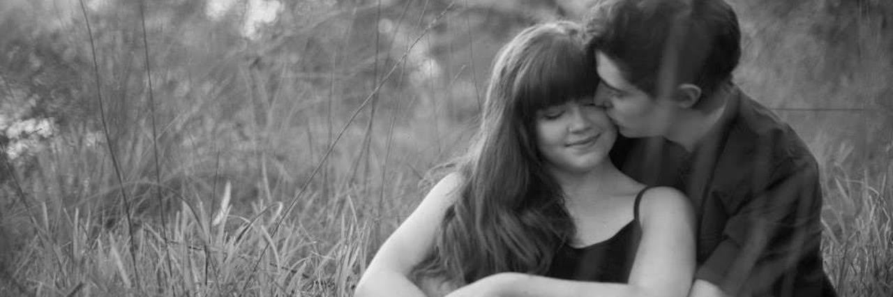 Being in a Relationship and Having a Chronic Illness black and white photo of boyfriend and girlfriend sitting in a field and hugging