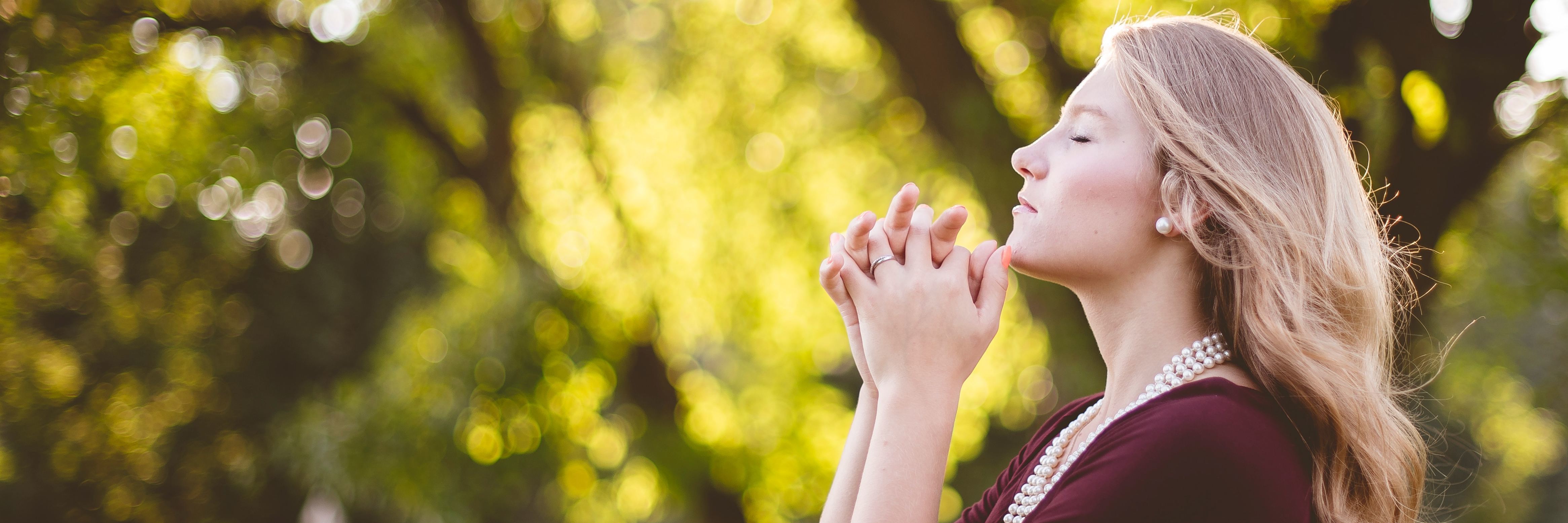 How I Combatted the Guilt I Felt as a Christian With Depression blonde woman in nature in front of tree praying