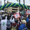 NAMIwalk mental health crowd carrying signs and balloon arch